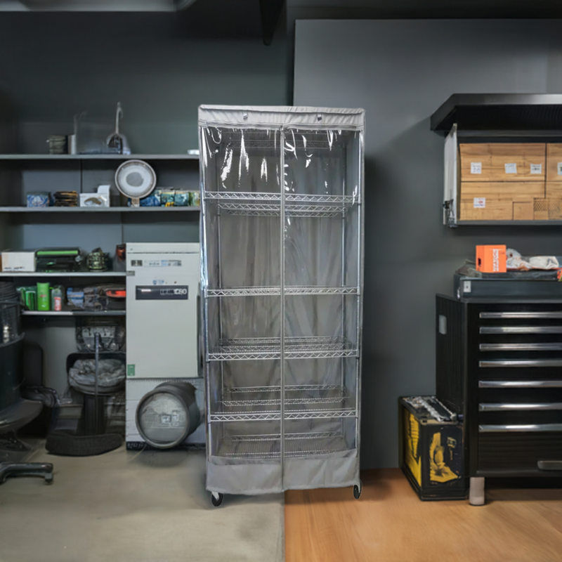 A tidy storage room features shelves covered with the Storage Shelving Unit Cover from Formosa Covers, which fits racks measuring 24"W x 18"D x 72"H and includes a see-through panel in grey. The room contains various items such as boxes, tools, and office supplies neatly organized on the surrounding shelves. Nearby is a cabinet with drawers, while a chair and some equipment are positioned on the left side. The shelves are protected by these clear PVC panels.